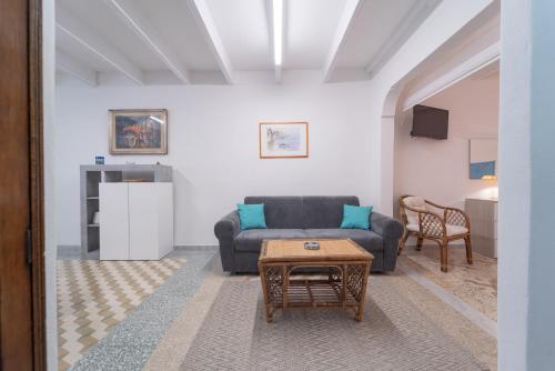 a living room with a couch and a table at Bene Ennidhos House - Alghero centro storico in Alghero