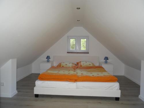 a bedroom with a white bed with two pillows at Schwedenhaus im Grünen in Oranienburg