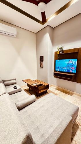 a living room with a couch and a flat screen tv at Jungle Guardian - Rooftop Pool & Beach Club in Zona Hotelera Tulum in Tulum