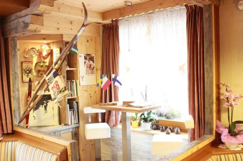 a room with a desk and a window and a lamp at Hotel Rosalpina in Soraga