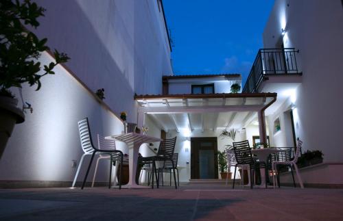 a group of chairs and a table in front of a building at Hotel Perla Gaia in San Vito lo Capo