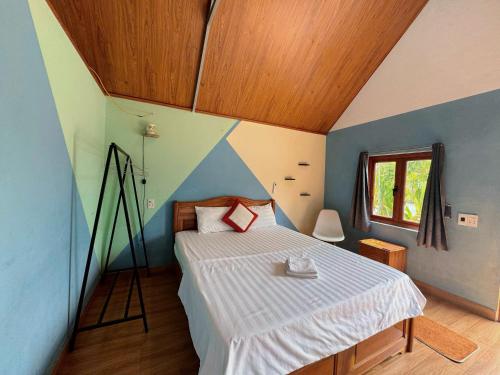 a bedroom with a bed and a wooden ceiling at Cat Ba Serena Homestay And Swimming Pool in Thái Bình