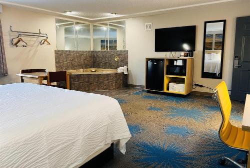 a hotel room with a bed and a television at Days Inn by Wyndham Jamestown in Jamestown