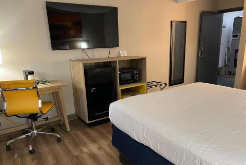 a bedroom with a bed and a desk and a television at Days Inn by Wyndham Jamestown in Jamestown