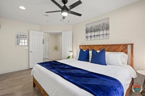 a bedroom with a large bed with blue pillows at The Ultimate Escape Pool, Slide, Gym plus Games! in El Cajon
