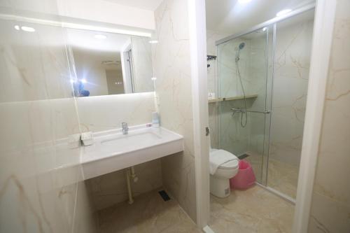 a bathroom with a sink and a shower and a toilet at Sea Keelung in Keelung