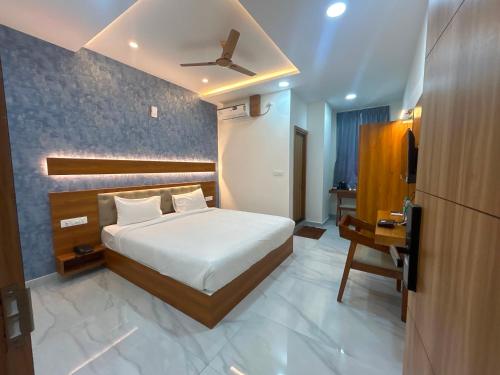 a bedroom with a bed and a desk and a television at Hotel O Golden Stay in Bengaluru
