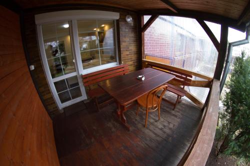 una vista elevada de un porche con una mesa de madera y un banco en Pension Thaya, en Znojmo