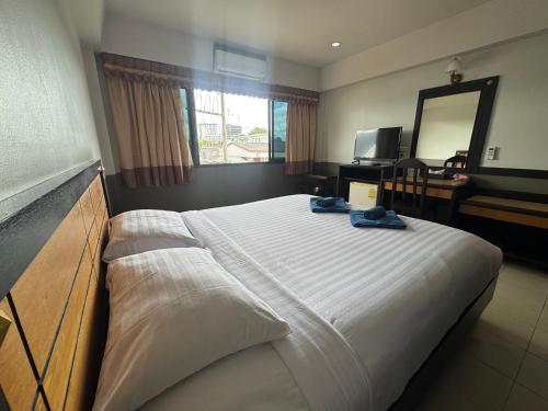 a bedroom with a large bed and a mirror at Ariya inn Chiangrai in Chiang Rai