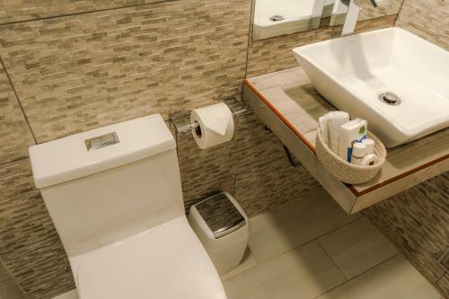 a bathroom with a white toilet and a sink at HOTEL PIEDRA SANTA - Moquegua in Moquegua