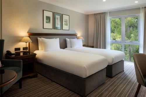 a hotel room with a large bed and a window at DoubleTree by Hilton Cheltenham-Cotswolds in Cheltenham