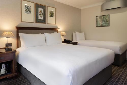 a hotel room with two beds and two lamps at DoubleTree by Hilton Cheltenham-Cotswolds in Cheltenham