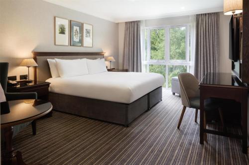 a hotel room with a bed and a desk at DoubleTree by Hilton Cheltenham-Cotswolds in Cheltenham