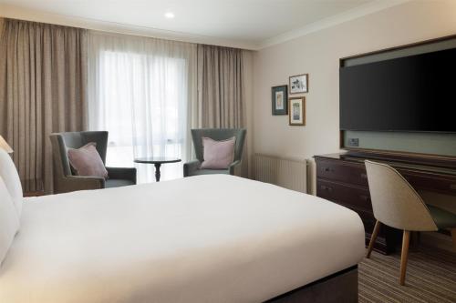 a hotel room with a bed and a flat screen tv at DoubleTree by Hilton Cheltenham-Cotswolds in Cheltenham