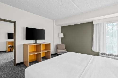 a hotel room with a bed and a television at Spark by Hilton Des Plaines Chicago O'Hare in Des Plaines