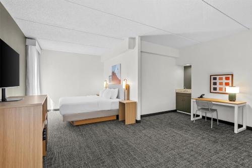 a hotel room with a bed and a desk at Spark by Hilton Des Plaines Chicago O'Hare in Des Plaines