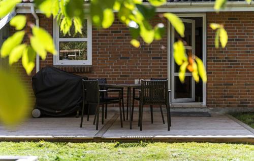 a patio with chairs and a table in front of a house at Holiday Home Kærhøgen Rømø Denm in Rømø Kirkeby