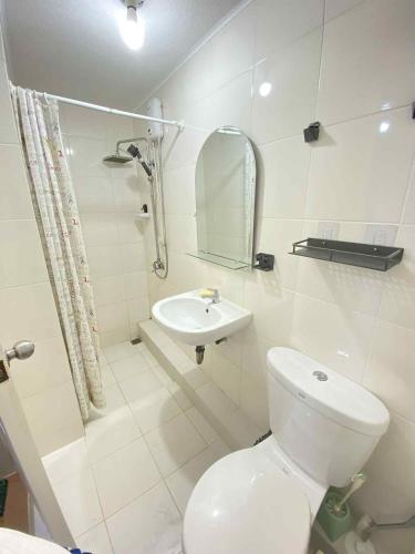 a white bathroom with a toilet and a sink at 2BR Condo Unit at San Remo Citi de Mare in Cebu City