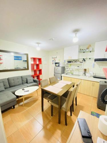 a kitchen and living room with a table and a couch at 2BR Condo Unit at San Remo Citi de Mare in Cebu City