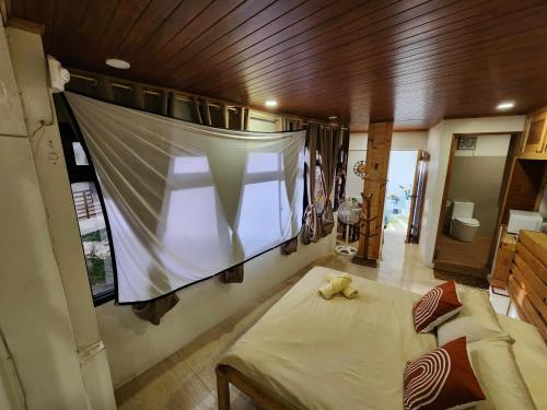 a room with a bed and a large window at Cozy Home - Mountain view in roof deck in Baguio