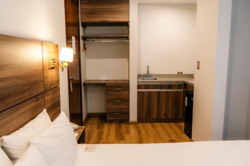 a bedroom with a bed and a kitchen with a sink at HOTEL PIEDRA SANTA - Moquegua in Moquegua