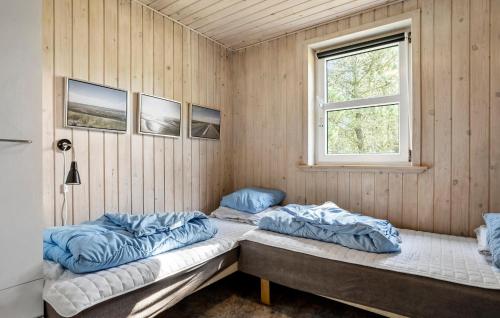 two beds in a room with a window at Holiday Home Kærhøgen Rømø Denm in Rømø Kirkeby