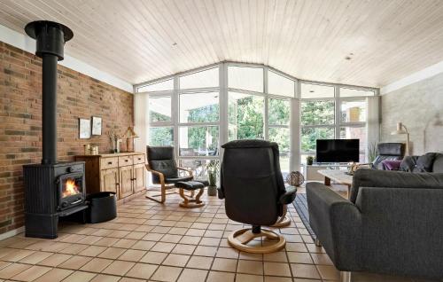 a living room with a couch and a fireplace at Holiday Home Kærhøgen Rømø Denm in Rømø Kirkeby