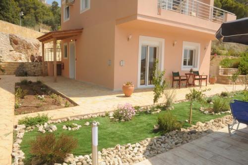 a house with a garden in front of it at Aegean View Villa in Loutraki