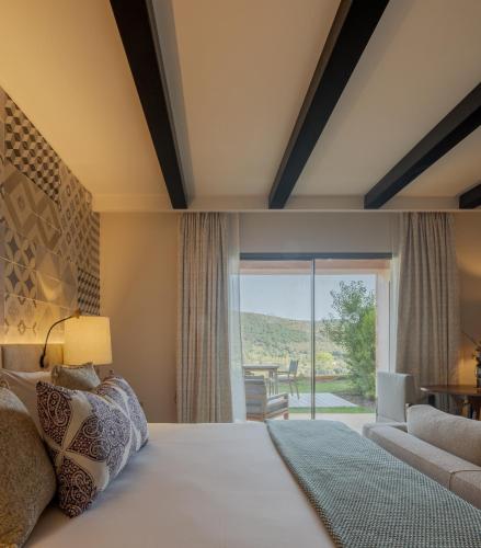 a bedroom with a large bed with a large window at Viceroy at Ombria Algarve in Loulé