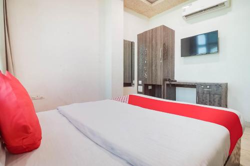 une chambre avec un lit blanc avec un oreiller rouge dans l'établissement Hotel O Cra, à Hisār