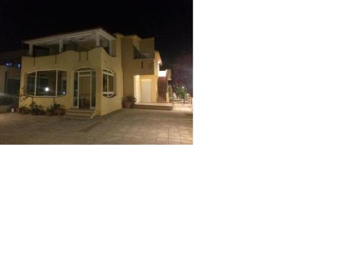 dos fotos de una casa por la noche en Villa Amico B&B San Leone, en Agrigento