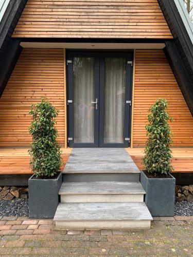 a front door of a house with two plants at Ferienhaus Eulennest in Billerbeck