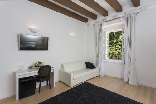 a living room with a white couch and a window at Rooms Klarisa Palace in Dubrovnik