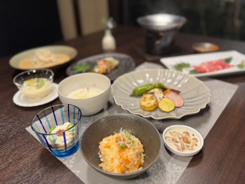 a table with plates and bowls of food on it at 旅庵 川喜 in Omachi