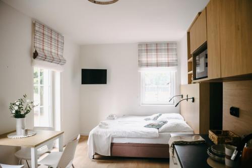 a bedroom with a bed and a table and a desk at Willa Marianna in Lądek-Zdrój