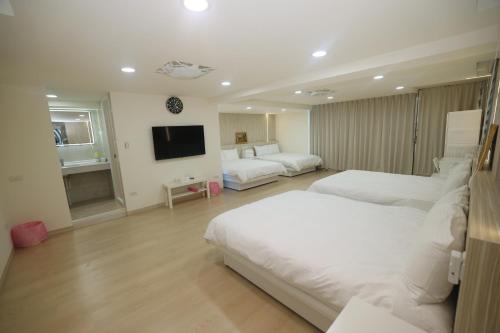 a hotel room with two beds and a flat screen tv at Sea Keelung in Keelung