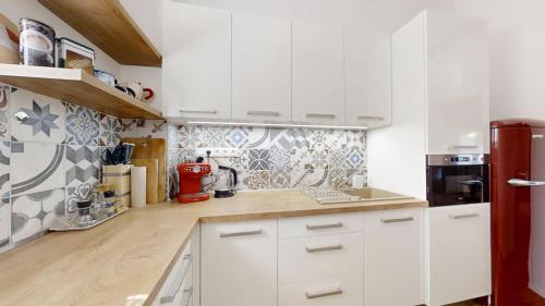 a kitchen with white cabinets and a red appliance at Old Town Loft in Žilina