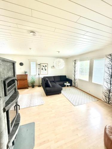 a living room with a couch and a fireplace at Polar Night Wooden House with Sauna in Sodankylä
