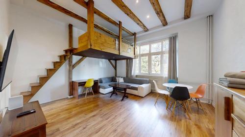 a living room with a staircase and a table and chairs at Old Town Loft in Žilina