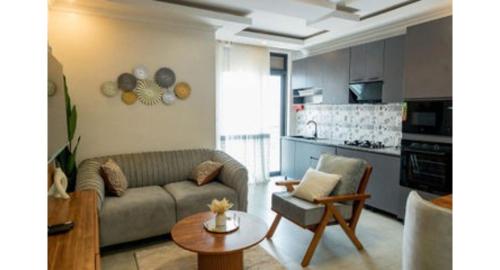 un soggiorno con un divano e un tavolo e una cucina di Tranquil Point Residence a Kigali