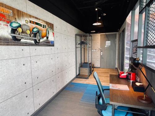 a room with a table and a painting of a car on the wall at T11、T12 Hotel in Houli