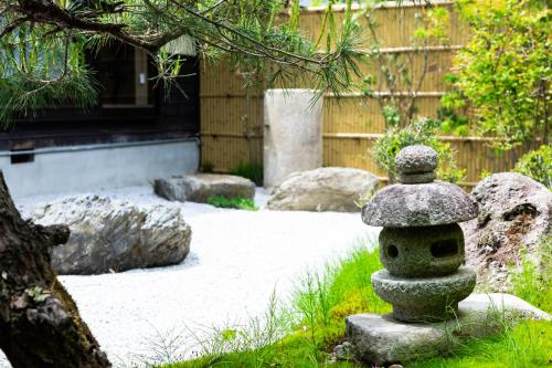 a stone statue in the middle of a garden at 旅庵 川喜 in Omachi