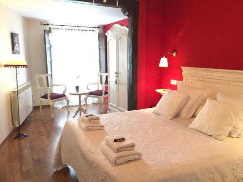 a bedroom with red walls and a bed with two towels at Casa del Infanzón in Sos del Rey Católico