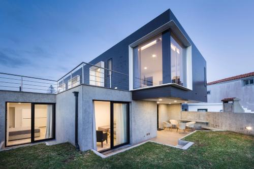 a house with large windows and a patio at XA Apartments RRAL-579 in Madalena
