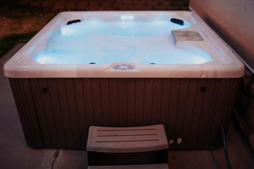 a bath tub with a bench in front of it at 5040 Sqft l Sleeps 25 l Near Ski & Downtown SLC in West Jordan