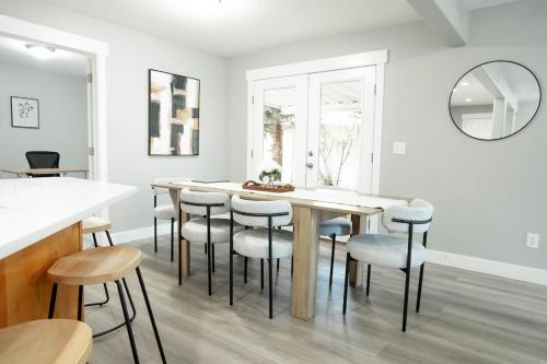 a dining room with a table with chairs and a mirror at 5040 Sqft l Sleeps 25 l Near Ski & Downtown SLC in West Jordan