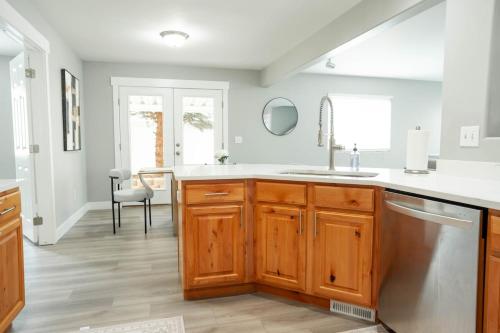 a kitchen with wooden cabinets and a sink at 5040 Sqft l Sleeps 25 l Near Ski & Downtown SLC in West Jordan