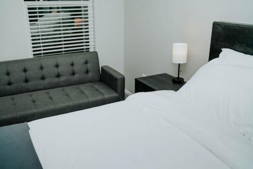 a bedroom with a bed and a couch at 5040 Sqft l Sleeps 25 l Near Ski & Downtown SLC in West Jordan