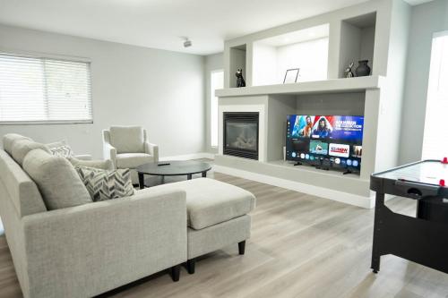 a living room with a couch and a tv at 5040 Sqft l Sleeps 25 l Near Ski & Downtown SLC in West Jordan