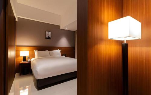 a hotel room with a bed and a lamp at Top Cloud Hotel Iksan in Iksan
